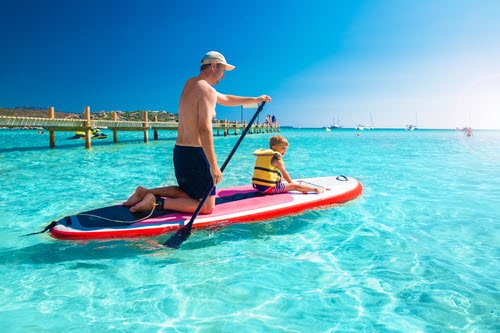 A father and son paddle boarding on the ocean